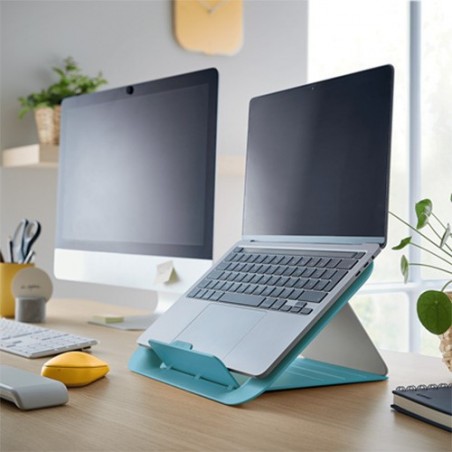 Laptop na podstawce Leitz Cosy w kolorze niebieskim, obok monitor.Wszystko stoi na biurku.