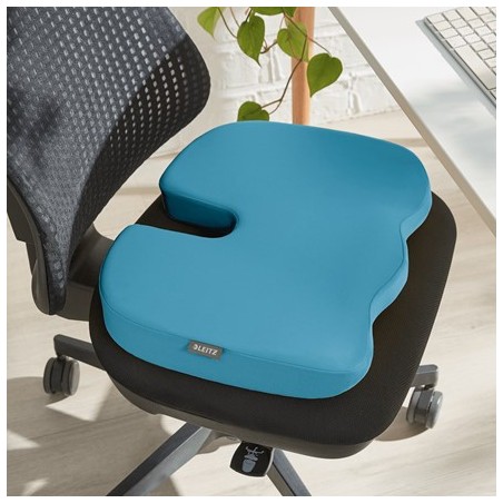 Poduszka Leitz Ergo Cosy w niebieskim kolorze, jest położona na czarne krzesło biurowe.